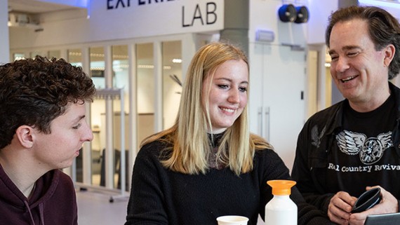 Docent helpt studenten met het opzetten van huj eigen bedrijf