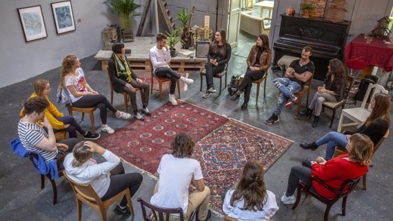 Studenten zitten op stoelen in een kring