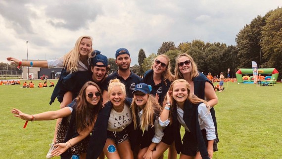 Groepsfoto van studenten op een sportveld