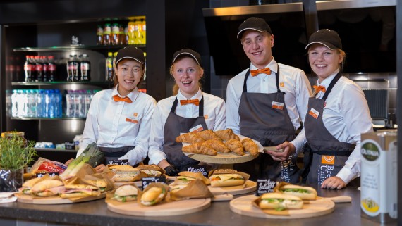 Vier studenten staan achter de balie van een BUas food court