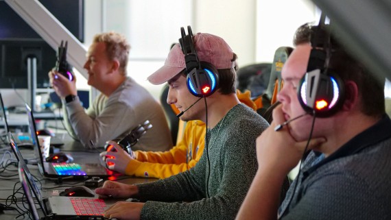 Drie studenten spelen een videogame