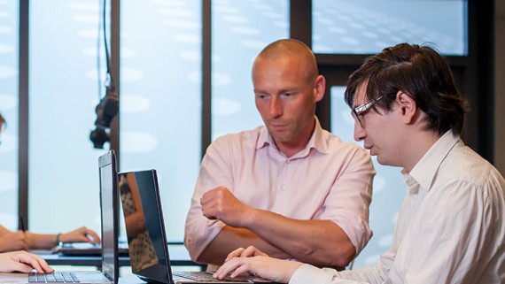 Twee mensen bekijken iets op een computer