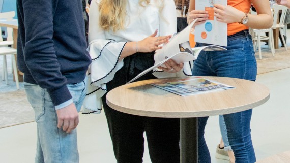 Studiekiezers en een student staan samen op de open dag 