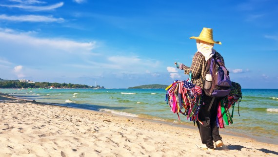 Een verkoper wandelt over het strand