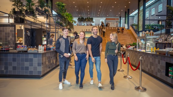 Vier studenten wandelen in het BUas Horizon gebouw