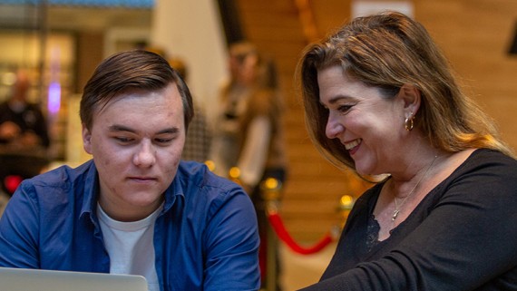 Een ouder en studiekiezer werken samen op een laptop