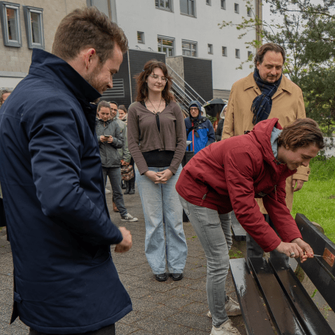 Jorrit Snijder en anderen kijken naar de opening van een bankje