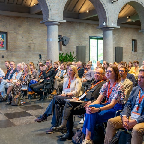 Een publiek luistert naar een presentatie