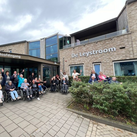 Groepsfoto van ouderen en begeleiders bij De Leystroom
