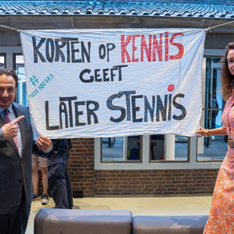 Jorrit Snijder en een vrouw staan bij een spandoek