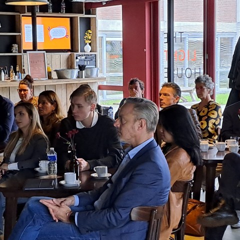 Een publiek luistert naar een presentatie