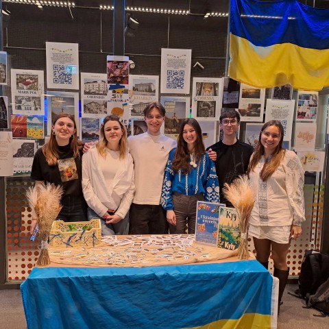 Studenten staan achter een tafel met de Oekraïnsche vlag
