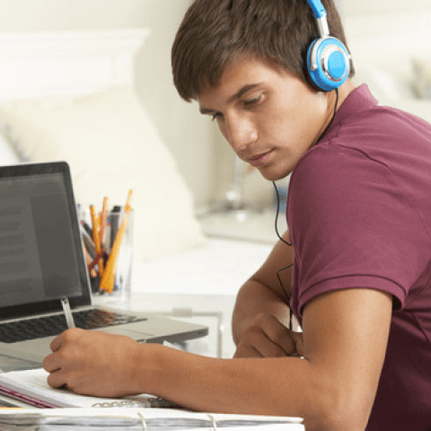 Student aan het werk met een koptelefoon op