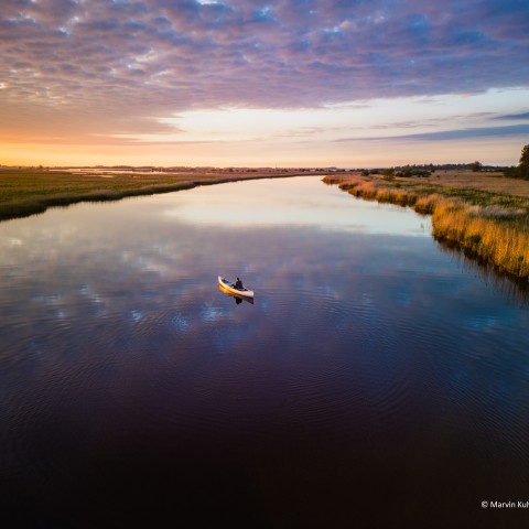 Een kano op een meer bij zonsondergang