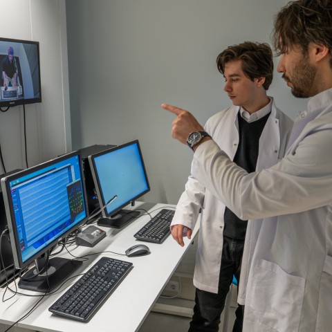 Twee onderzoekers analyseren resultaten op een computer