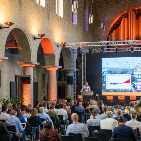 Deelnemers luisteren naar een spreker in de Kapel bij BUas