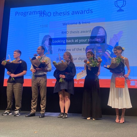 Studenten staan op een podium bij de thesis awards 