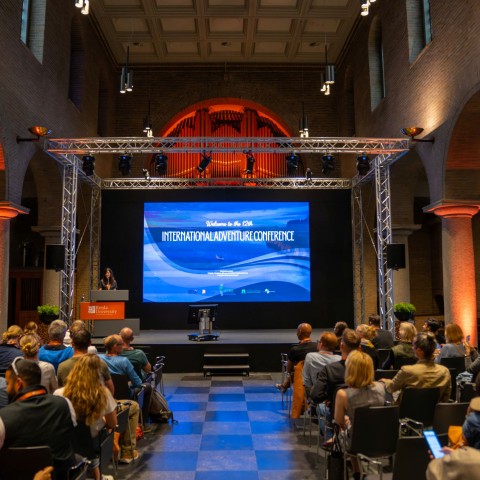 Deelnemers zitten in de zaal en wachten tot het IAC begint