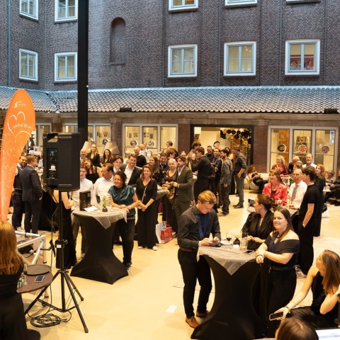 Gasten van het event staan aan verschillende sta-tafels