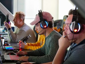 Drie studenten spelen een videogame