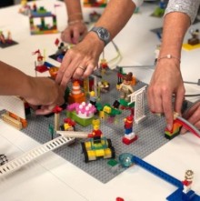 Vier handen bouwen iets met LEGO