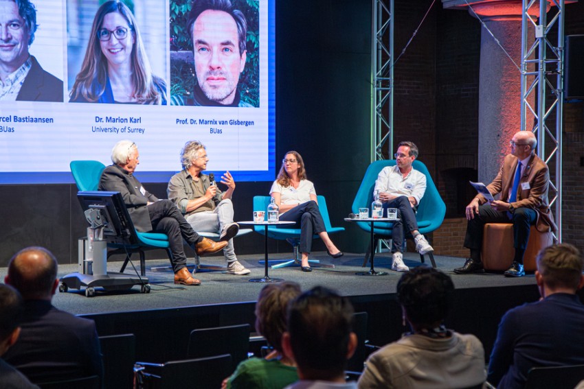 Een panelgesprek op een podium tijdens een symposium