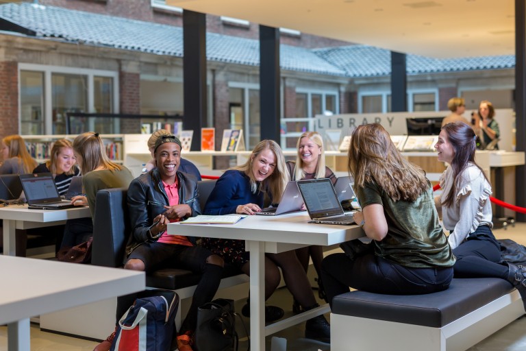 Een groepje lachende studenten voor de BUas library