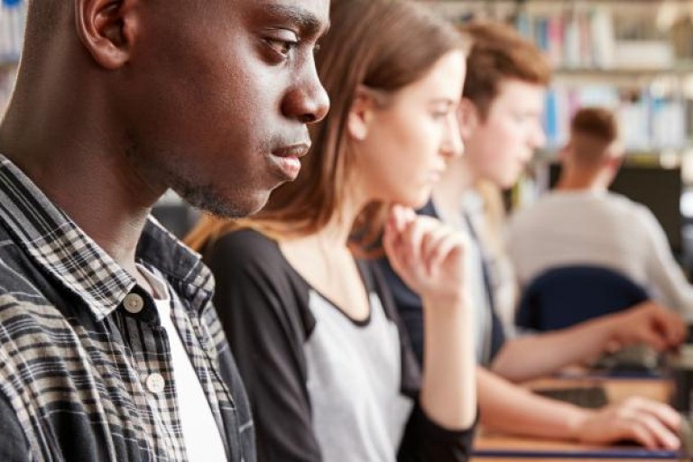 Studenten werken achter desktop computers