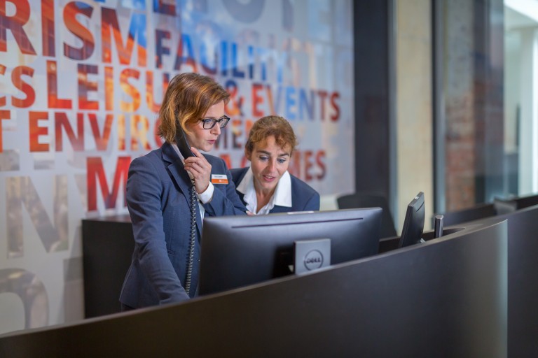 Twee medewerkers bij de receptie van BUas