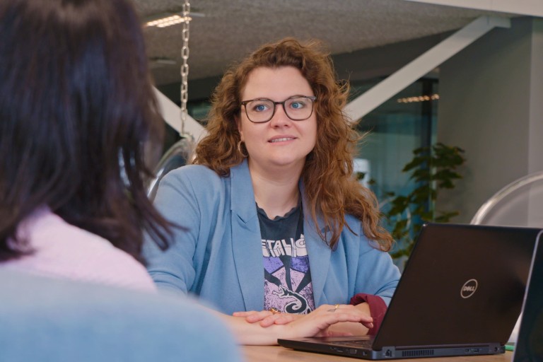 Een docent zit achter een laptop
