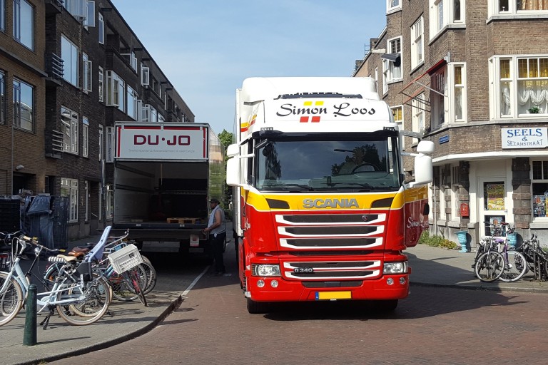 Ee vrachtwagen in een smalle straat