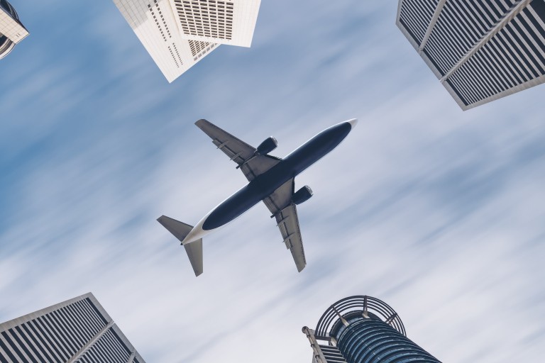 Een vliegtuig vliegt laag over een grote stad