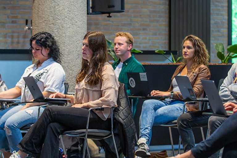 Studenten luisteren naar een college in een grote zaal