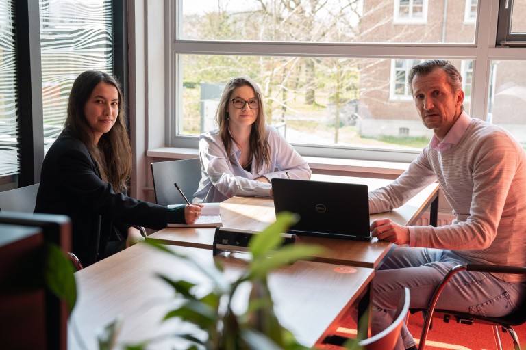 Een docent en twee studenten zijn in overleg