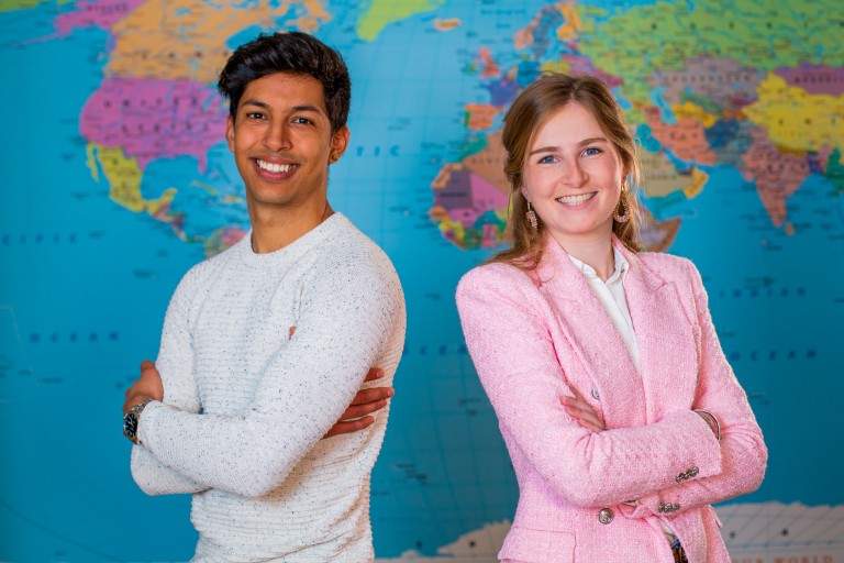 Twee studenten staan voor een wereldkaart