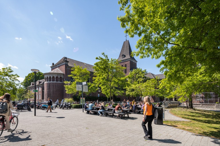 Studenten lopen, fietsen en zitten op de BUas campus
