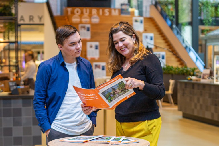 Moeder en zoon bekijken een BUas brochure