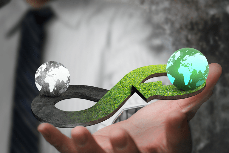 Een hand houdt groene en een donkere wereldbol vast 