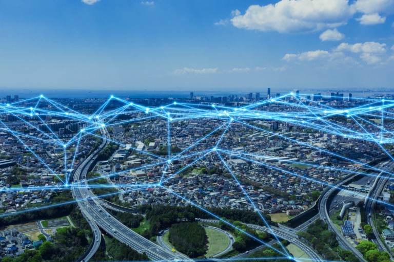 Luchtfoto van een stad met een digitaal netwerk erover