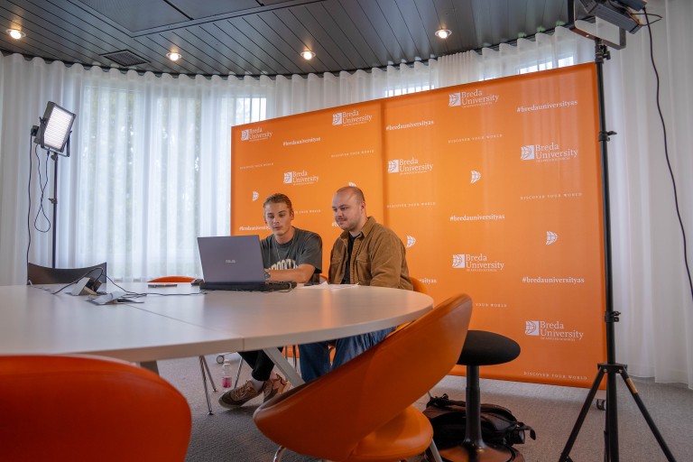 Twee studenten zitten voor een laptop voor de online open dag