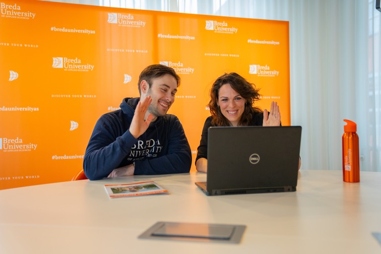 Een docent en student zwaaien naar een laptop
