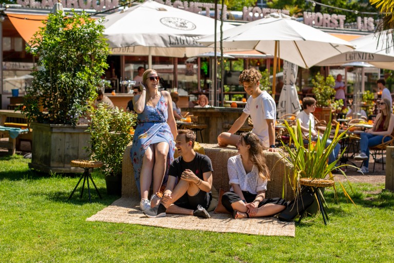 Studenten zitten bij een terras in het park in Breda