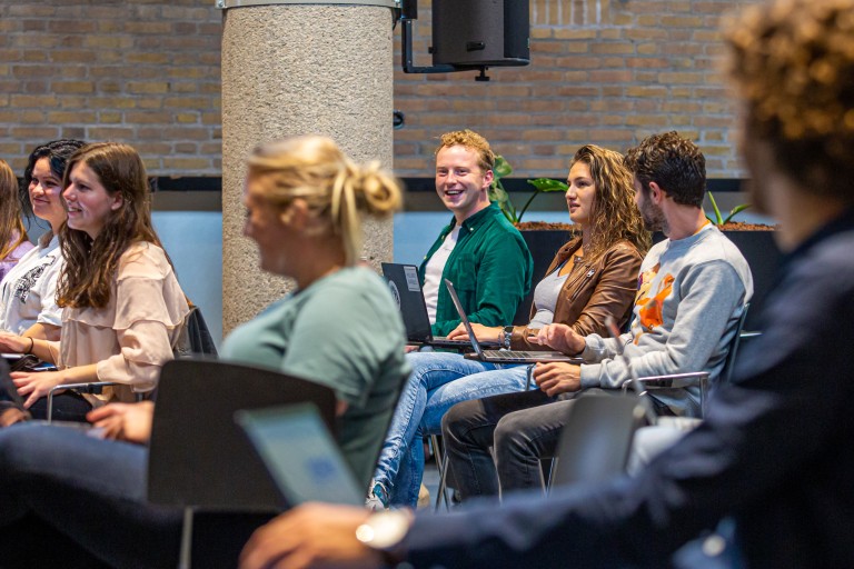 Studenten met een laptops luisteren naar een uitleg