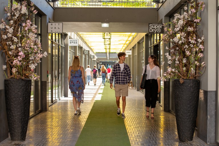 Studenten lopen door een overdekte winkelpassage in Breda