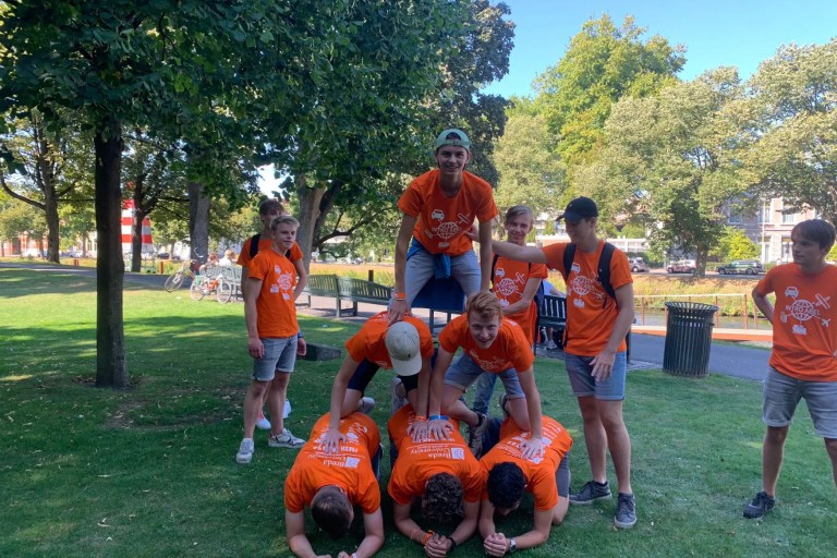 Studenten zitten op elkaar in een menselijke piramide 