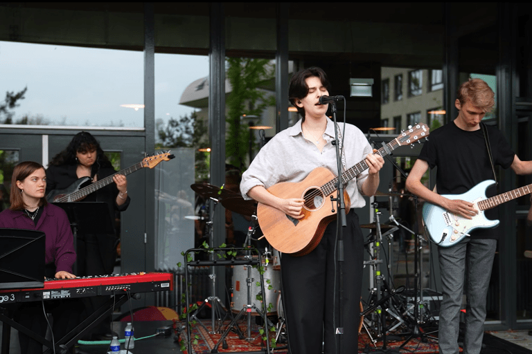 Een band van studenten treedt op op een podium