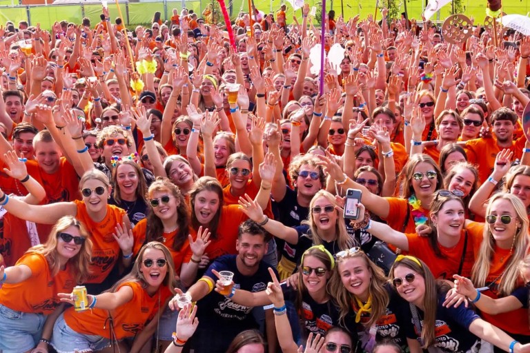 Groepsfoto van een grote groep lachende studenten