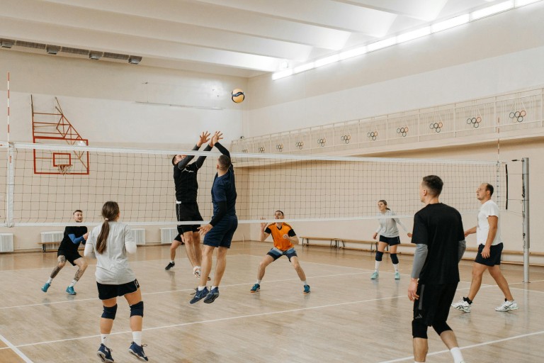 Studenten spelen volleybal in een sportzaal