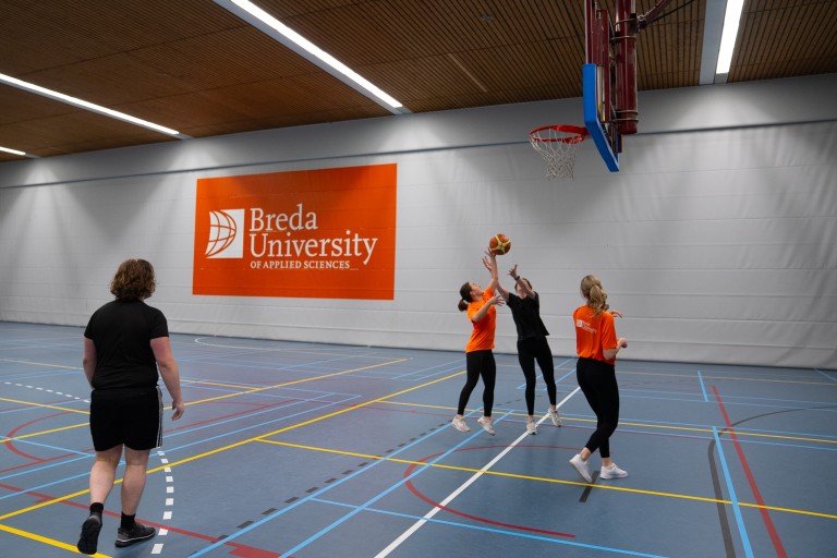 Vier studenten spelen basketbal