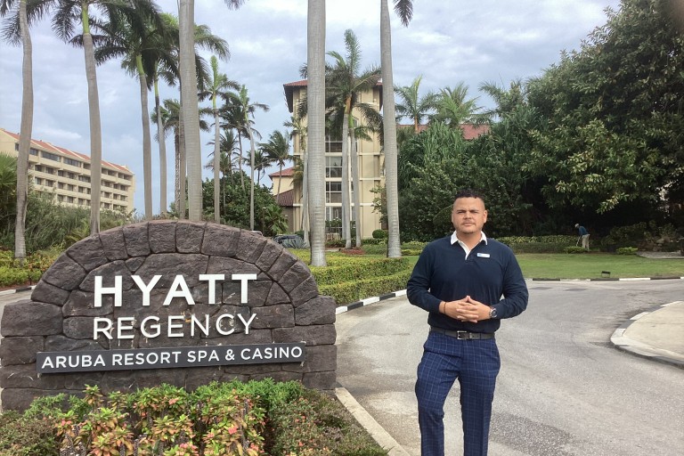 Jean Paul Thijzen staat naast het Hyatt hotel op Aruba